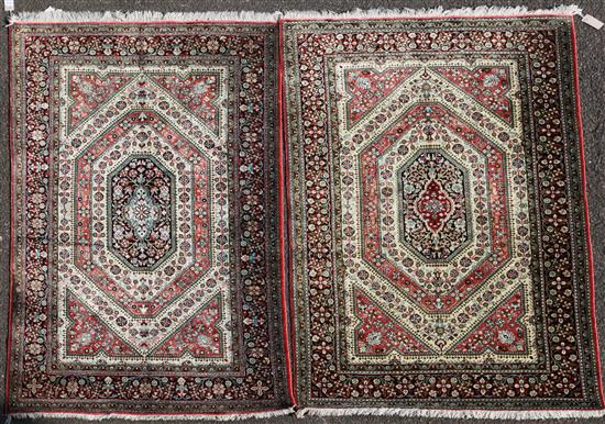 A mathched pair of Qum silk rugs, 5ft 4in by 3ft 4in.